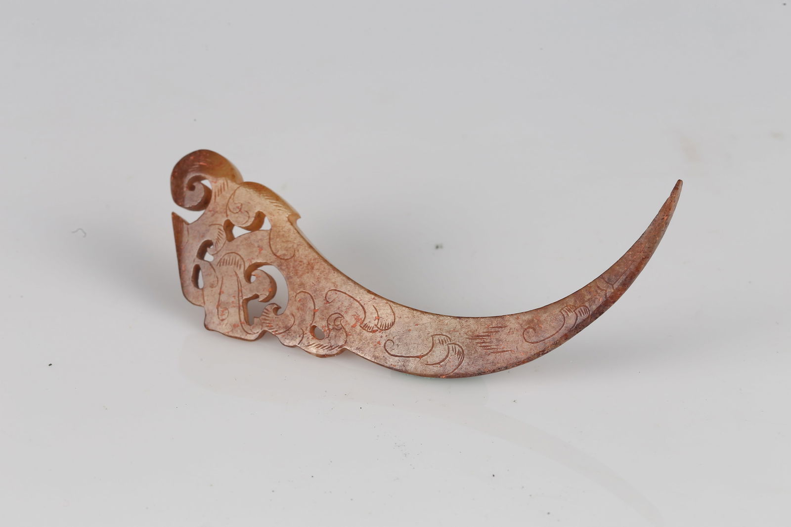 A Jade Carved 'Dragon' Xi Pendant: 漢 玉龍紋觹 Carved as a stylized dragon, the elongated body curves in a sweeping crescent terminating in a finely tapered point, the head articulated with scrolling horns
