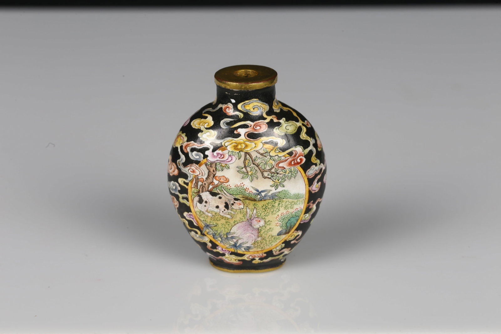 A Canton Enamel Copper 'Rabbit' Snuff Bottle: 雍正年製款 銅胎畫琺瑯兔紋鼻煙壺 The ovoid body finely painted with a panel on each side enclosing a pair of
