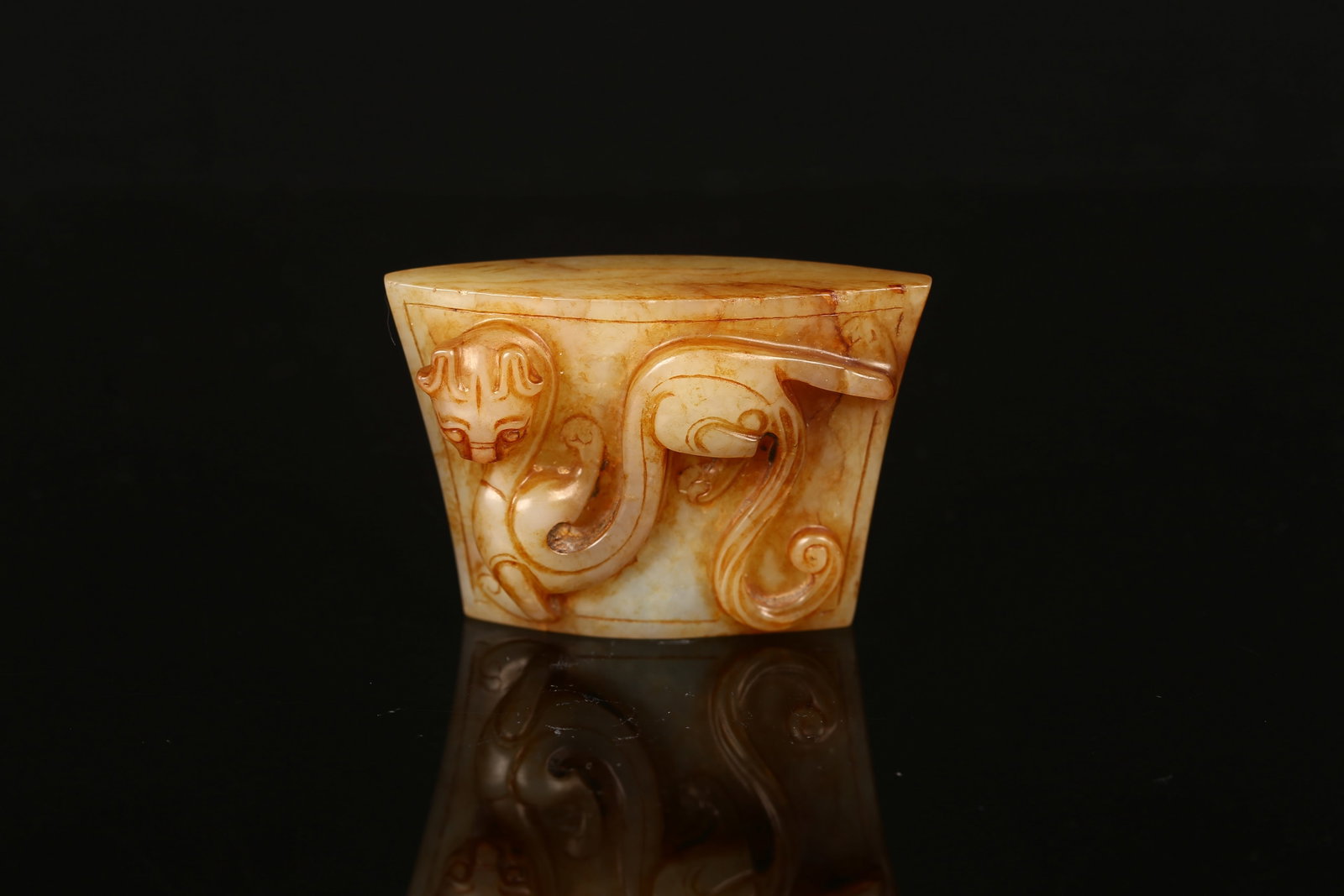 A White Jade 'Mythical Beast' Sword Fitting: 高浮雕螭尤劍珌 The ring of slightly tapering form, boldly carved in high relief with a sinuous chilong clambering across the exterior, its bifurcated tail