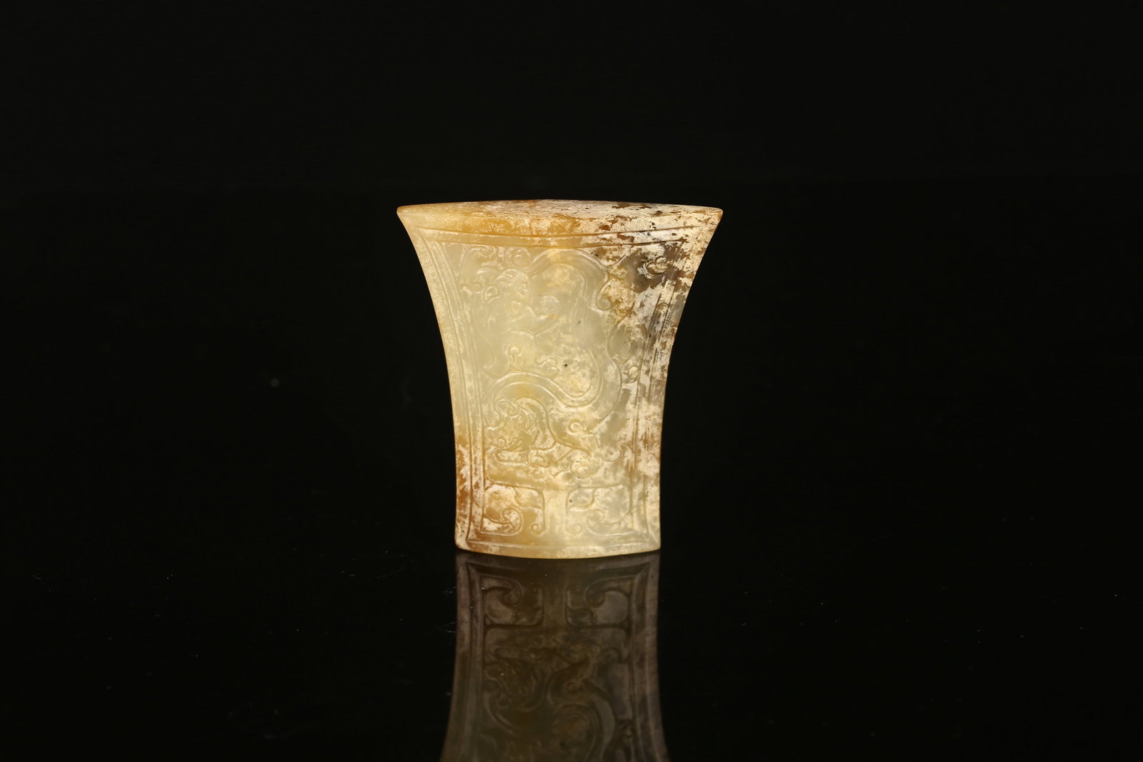 A Chinese Jade 'Chilong' Sword Fitting Chape: 青玉浮雕螭龍劍珌 Chinese. Of trapezoidal shape and lenticular section, carved on both sides with sinuous chilong enclosed with double line border, the