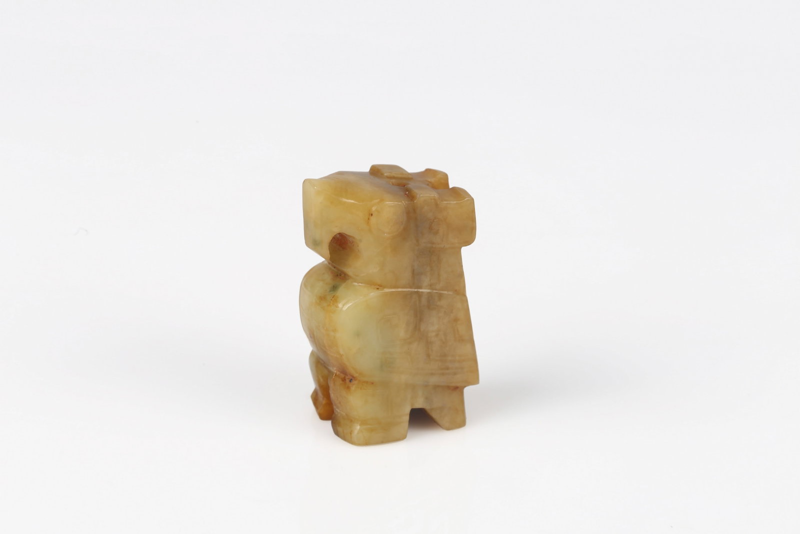 A Yellow Jade Carved Owl: 商 黃玉玉鸮 The owl carved standing, with squared head, rounded eyes and hooked beak, the wings indicated in low relief along the sides, the stone of a yellow-celadon ton