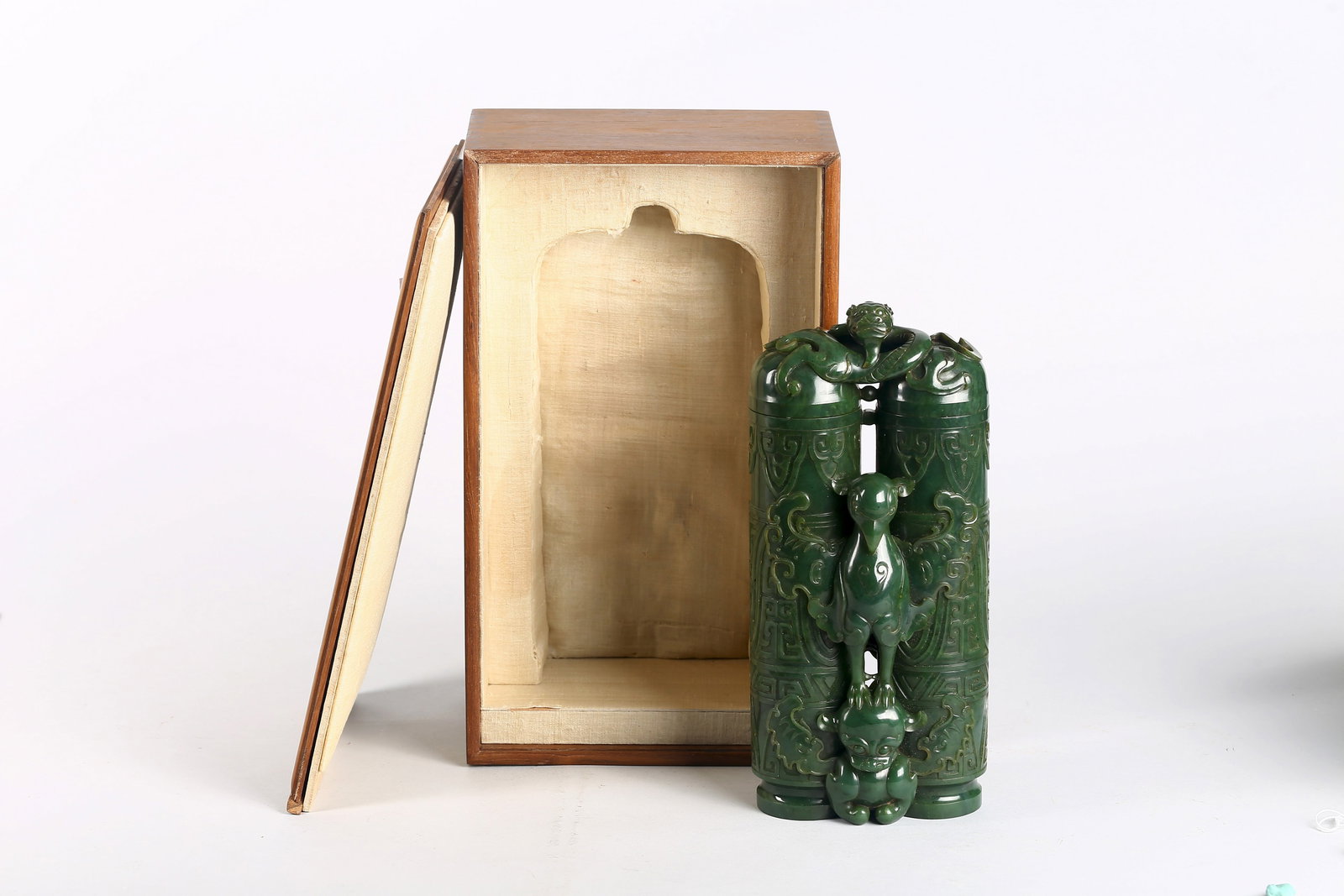 A Large Green Jade 'Champion' Vase and Cover: 清 大型碧玉英雄雙聯瓶 Carved as a conjoined pair of cylindrical vessels surmounted by a reticulated sinous dragon form cover, the sides