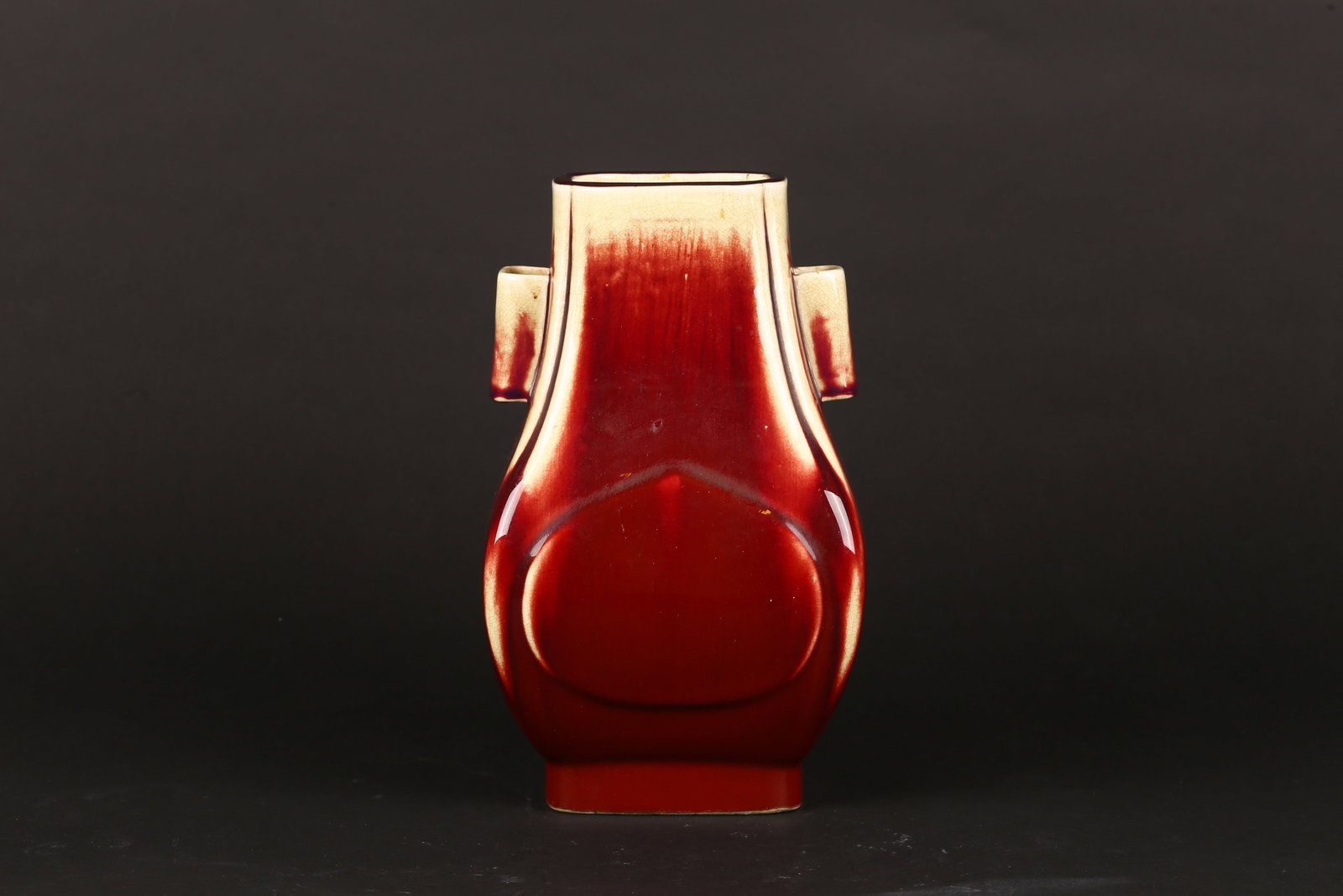 A Flambe Red Glazed 'Hu' Vase: 清 窑变釉貫耳壺 Of archaistic hu form with tubular lug handles, covered in a rich flambé glaze of deep copper-red tone, thinning to a pale buff at the rim an