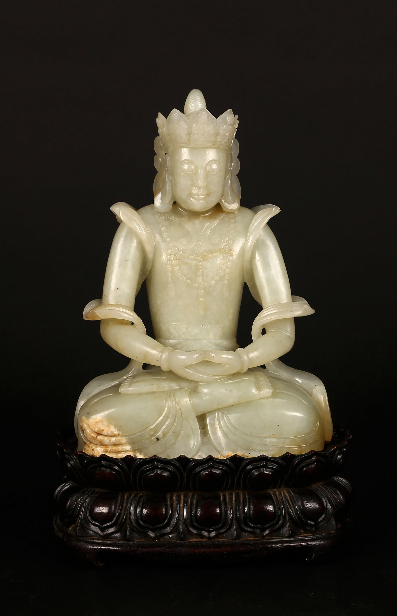 A White Jade Carved Amitayus and Hardwood Stand: 清 白玉雕無量壽佛 紅木座 Carved in the round and seated in dhyanasana with hands joined in meditation, the serene figure adorned with