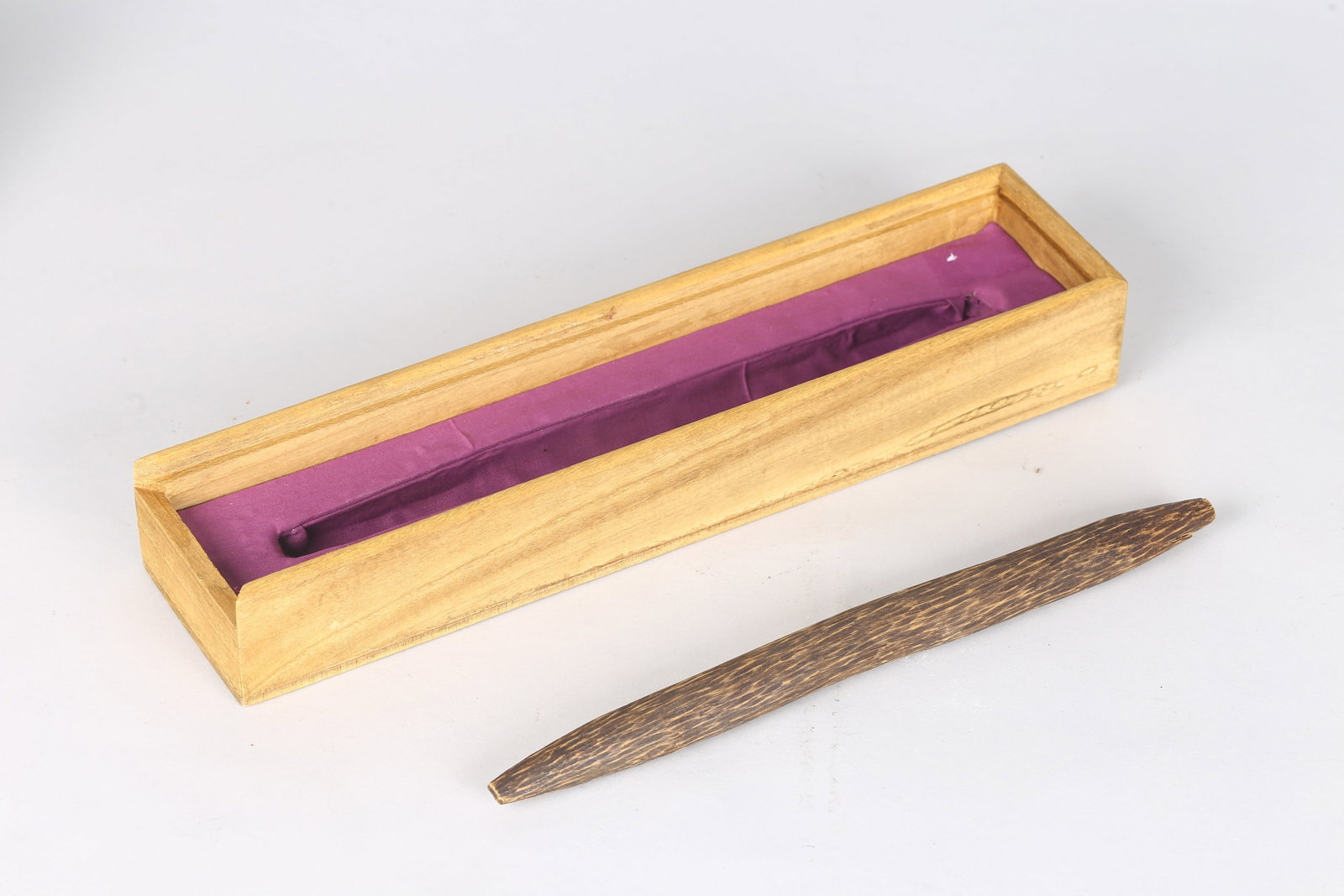 An Aloeswood Piece?100g?: 天然沉香一件 100克 Of elongated, gently curved form tapering at both ends, the aloeswood shows dense, oil-rich grain with variegated golden-brown patterning, 