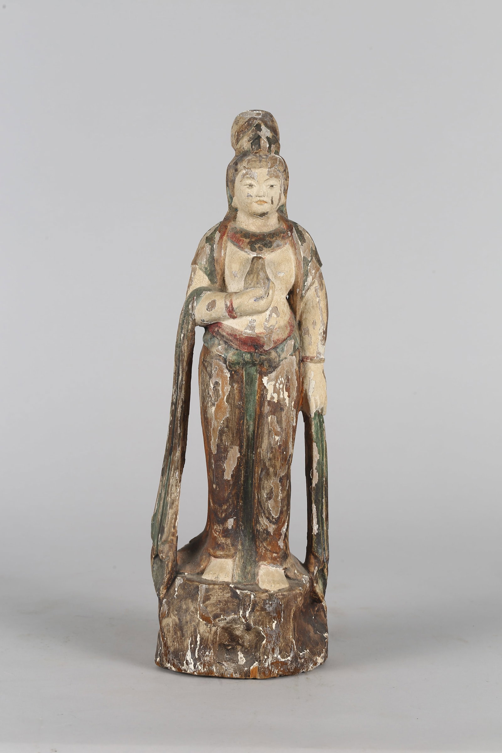 A Chinese Polychrome Wood Figure of Bodhisattva: 清 木雕彩繪菩薩立像 The bodhisattva is depicted standing in a graceful posture on a rockwork base. The figure has a full face with a serene