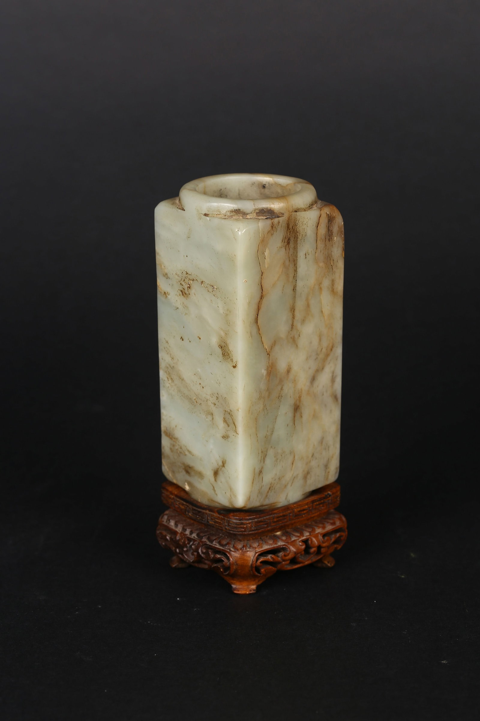 A Small Jade Carved 'Cong' Vase: 清 青白玉琮式小瓶 Of rectangular section with a cylindrical mouth, carved in imitation of an archaic cong, the pale celadon stone with russet inclusions