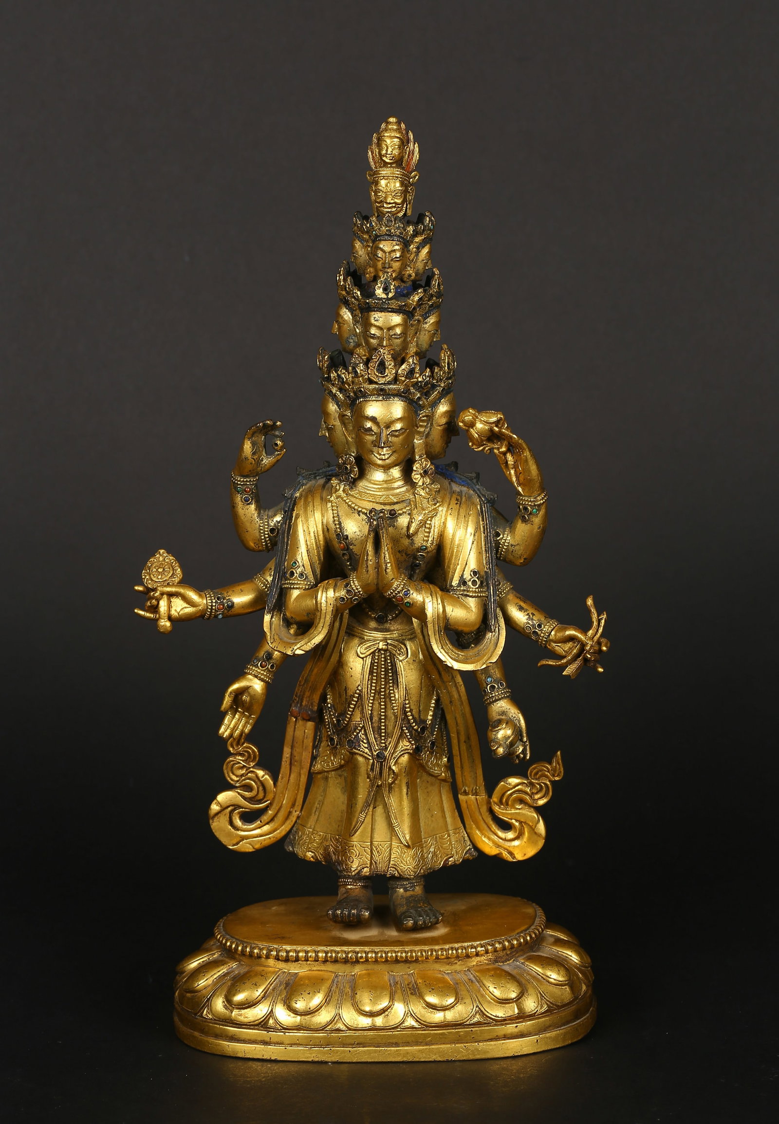 A Gilt-Bronze Figure of Eleven-Headed Avalokiteshvara: 清早期 銅鎏金十一面八臂觀音立像 Cast standing on a double-lotus base, the eleven-headed Avalokiteshvara finely