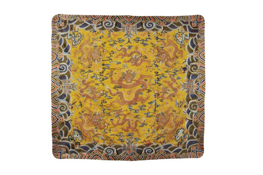 An Imperial 'Nine-Dragon' embroidered throne cushion: Richly embroidered in yellow, red, blue, cream, and green silk contrasting with brilliant gold-wrapped thread depicting a front-facing five-clawed dragon encircling a flaming pearl whilst clutching a