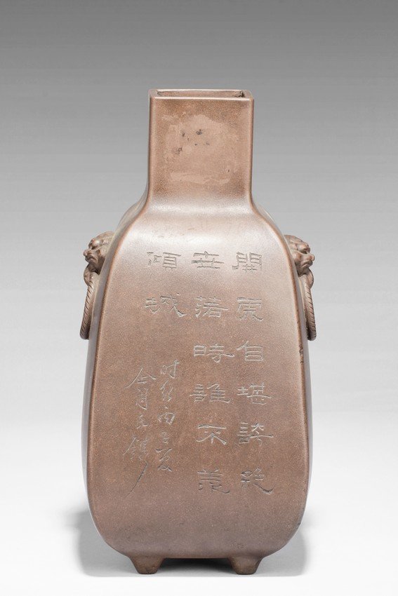 QI TAOSHI: A ZISHA RECTANGULAR VASE WITH HANDLES: Of rounded rectangular form, the body stands on four small foot, the body carved with Chinese poem and a mountain scene, with a pair beast masks and loop ring handles on the side. Artist signature and