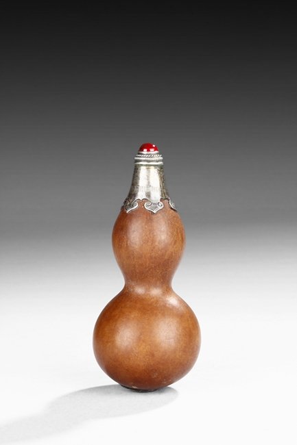 A FINE "DOUBLE GOURD" SNUFF BOTTLE: Made from natural double gourd, the snuff bottle retains the natural color and grains, the top encased in metal with ruyi cloud pattern, the bottom metal in lotus leaf form, the stopper of bright red