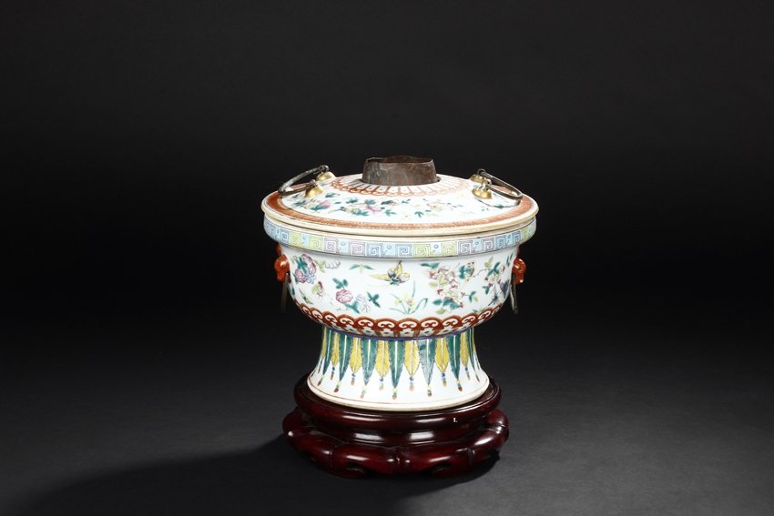 A FAMILLE ROSE HOTPOT AND COVER: Supported by long splayed foot, the flaring body rises to an everted rim with a cover. The foot is decorated with leaves motif with a opening to the reverse and the body is painted with flower sprays 