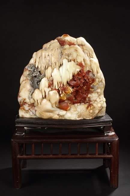 A LARGE CARVED SOAPSTONE BOULDER SHANZI: The large boulder Shanzi cleverly carved to a mountain and river scene, with an elder fishing on his boat, below plum flower trees, close to pine trees and mountains, two birds snatching up fishes clo