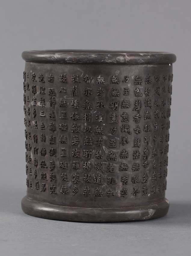 A CHINESE CALLIGRAPHY BRUSH-POT: The brush-pot is made from ironwood and has the Heart Sutra in Chinese calligraphy carvings wrapped around the pot. A carved Chinese artist seal is found on the back side. H: 5 1/2 in (14cm) W: 5 in (