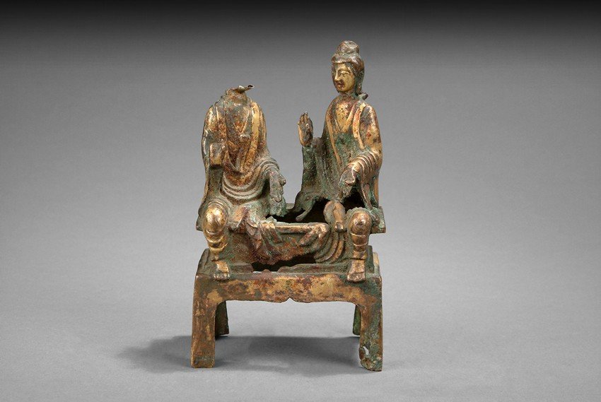 A BRONZE FIGURAL GROUP OF TWO BODHISATTVA: The two Bodhisattva seated in Lalitasana on a rectangular plinth, each wearing loose robe and holding different mudra. Missing one Bodhisattva's head. North Wei Dynasty period. H: 7 1/8 in (18.1 cm) W