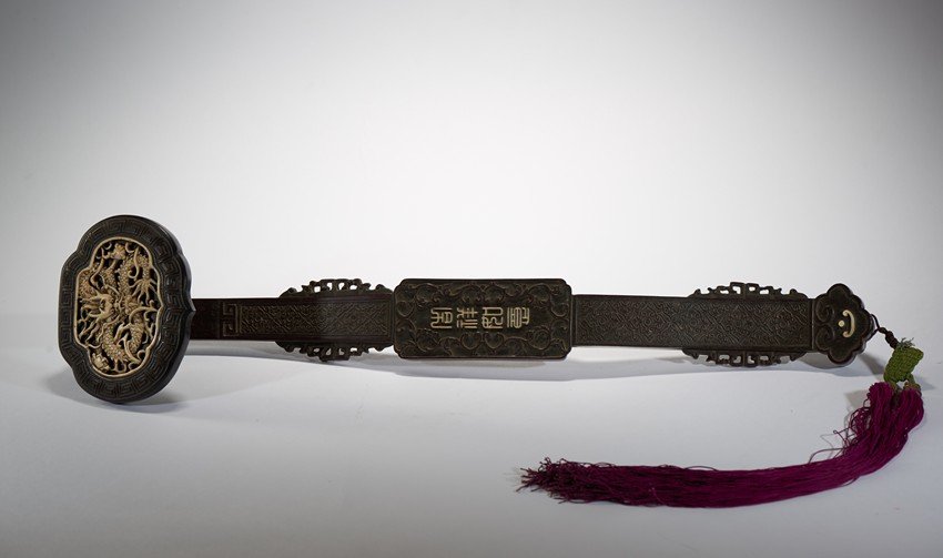 A ZITAN AND BONE DECORATED 'DRAGON' RUYI SCEPTER: The scepter head is finely inlaid with an bone openwork dragon plaque enclosed by key-fret border, the handle with four stylized characters 'Ji Xiang Ru Yi' translated 'good fortunes as one wishes' en