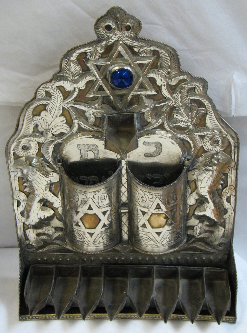 ANTIQUE MIDDLE EASTERN SILVER MENORAH: MIDDLE EASTERN ANTIQUE SILVER MENORAH IN THE BAAL SHEM TOV STYLE WITH BACK PLATE WITH SILVER OVER BRASS APPLIED IN THE FORM OF LIONS & HEBREW WRITING OF THE TEN COMMANDMENTS. THE MENORAH IS ADORNED WI