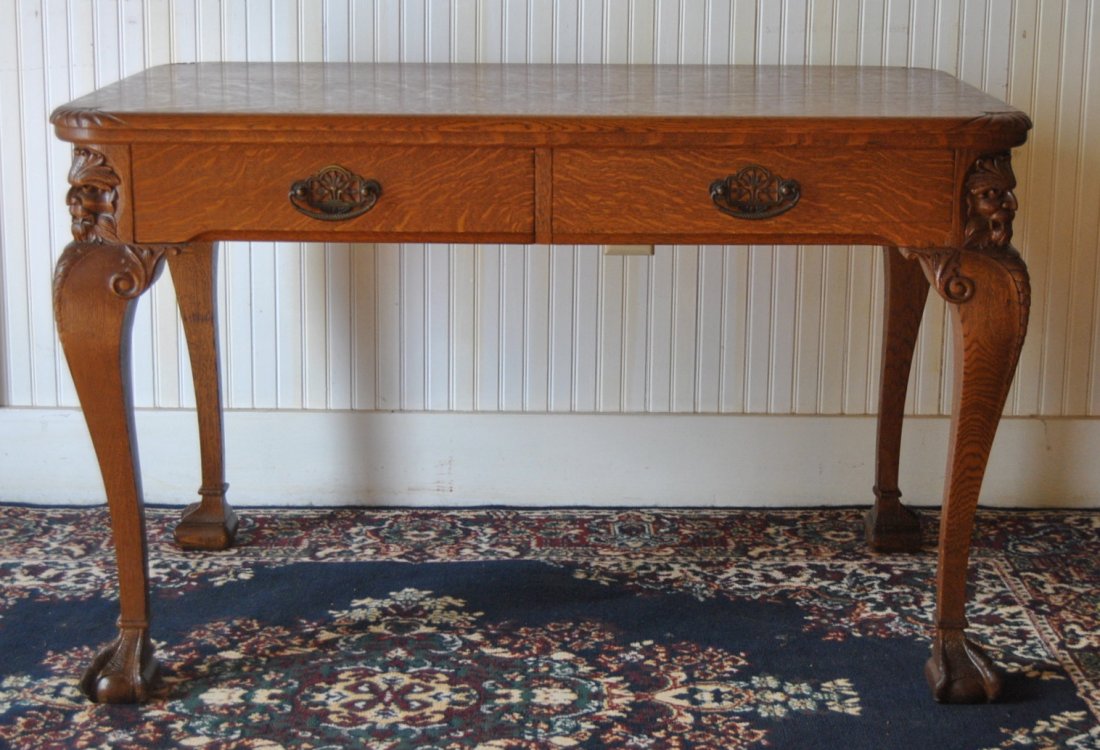 Two Drawer Oak Library Table w/ Carved Lions: Two drawer oak library table w/ carved faces at corners, H:29" D:28" W:45.5"