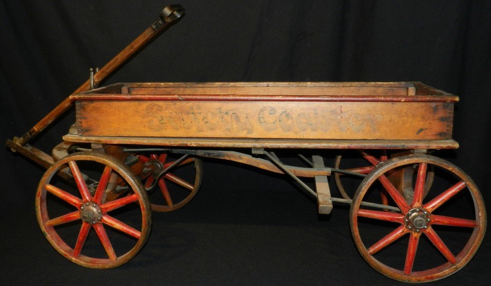 Antique Wood Spoke Wilkenson Coaster Wagon Hand Brake: Handmade wood spoke wheeled coaster wagon. This was made by the Wilkenson Manufacturing Company and features the title "Safety Coaster" on the sides. There is a hand brake on this wagon. The coaster m