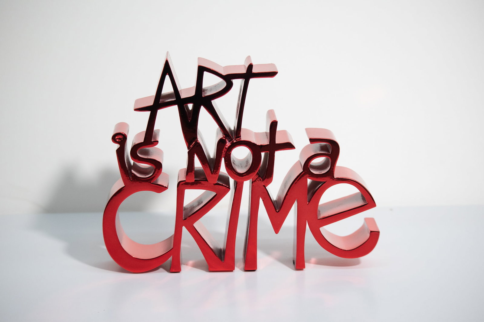 Mr. Brainwash - ART IS NOT A CRIME (Chrome Red): Artist: Mr. BrainwashTitle: ART IS NOT A CRIME (Chrome Red)Year: 2021Dimensions: 7 1/2in. by 8in.Edition: From the Rare Limited edition of 95Medium: Cast Resin Acrylic sculpture with metaic