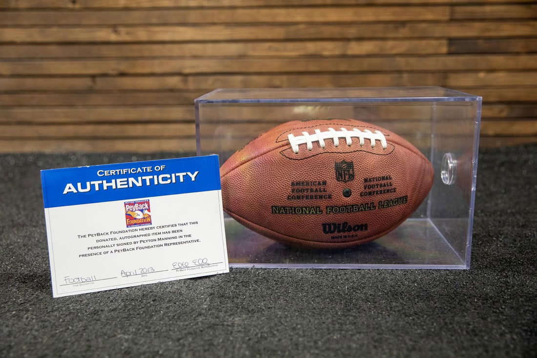 Peyton Manning Autographed Football and Display Case: Peyton Manning autographed football and display case accompanied by a certificate of authenticity.