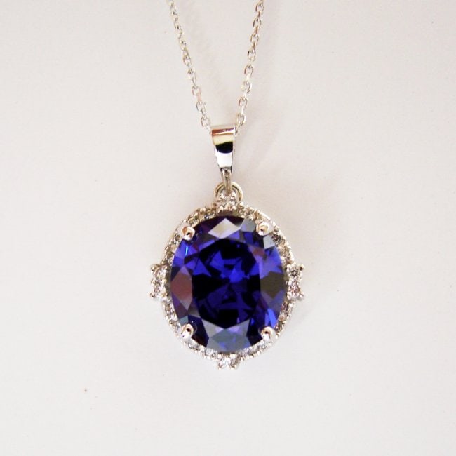 Creation Diamond/Tanzanite Pendant 7.72Ct 18k W/g: Gem: Creation Diamond/Tanzanite Qty: 1 Item: Pendant Diameter: 16x14mm Center stone: 7.45 carat oval shape, size 16x14 mm Clarity: VSI, Color: Dark Violet Blue 22 Pcs Creation Diamond: .27 carat round