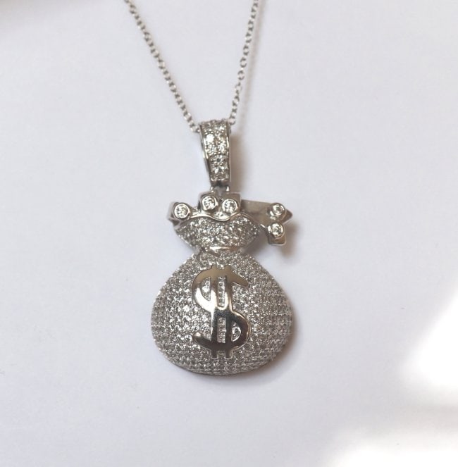 Hip Hop Money Bag Creation Diamond 1.50Ct 18k W/g Overlay: Pendant: Money Bag Hip Hop Length: 1.50 Inches Width: .75 Inch Stone Total: Approx. 1.50 Carat round brilliant Clarity: VSI, Color: F Metal: 18k White gold overlay 925 silver (9.90 grams) No