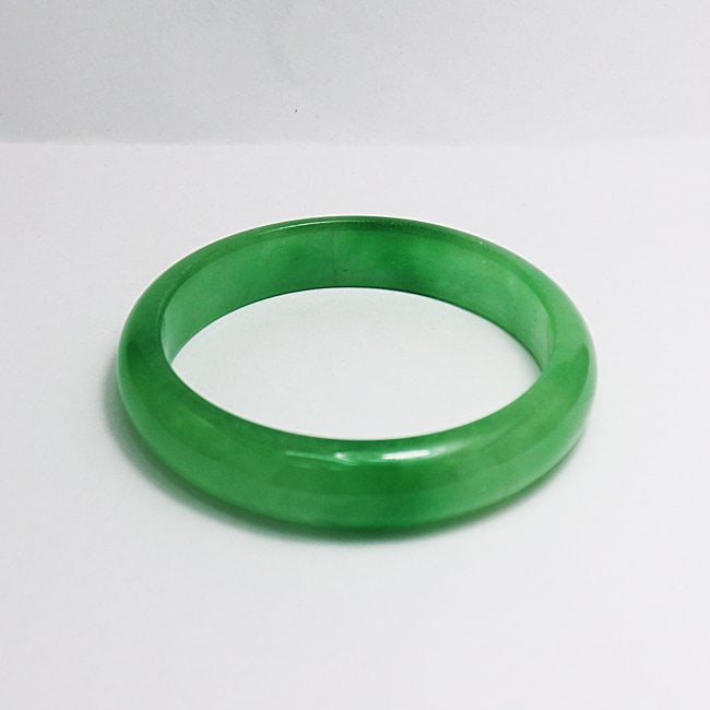 Translucent Solid Green Chinese Jade Bangle Size: 6: Gem Type: Natural Translucent Solid Chinese Jade Grade: B Item: Jade Bangle, Size 6 Outer Diameter: 67mm Inter Diameter: 55 mm Width: 12.5 Thickness: 7 mm Weight 45.36 grams Treated: