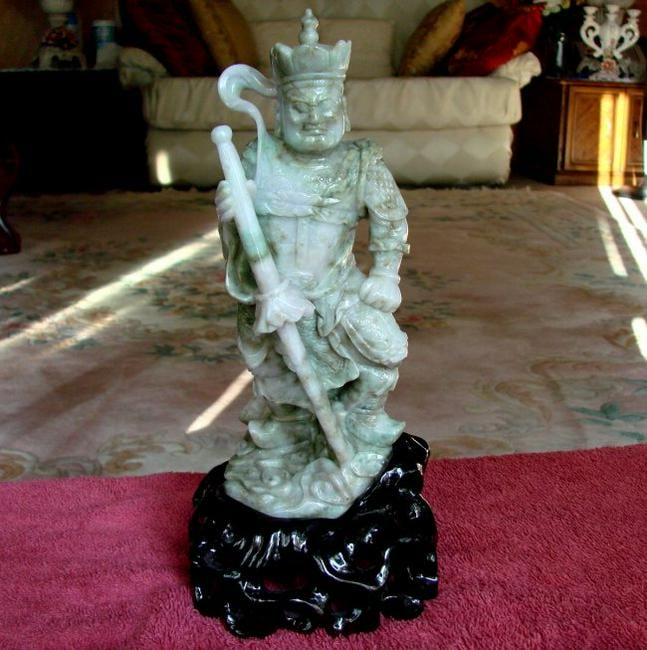 19th Century Jade Carving Famous Dragon Gong Guanyu: Gem:Jade Dragon Gong Guanyu Warrior Statue with a Sword 19th Century Weight: 3.5 Pounds Height: 9" x Width: 3.5" Color: Light green, Brown Texture Stand: Caving Wood color rich burgundy This item carv