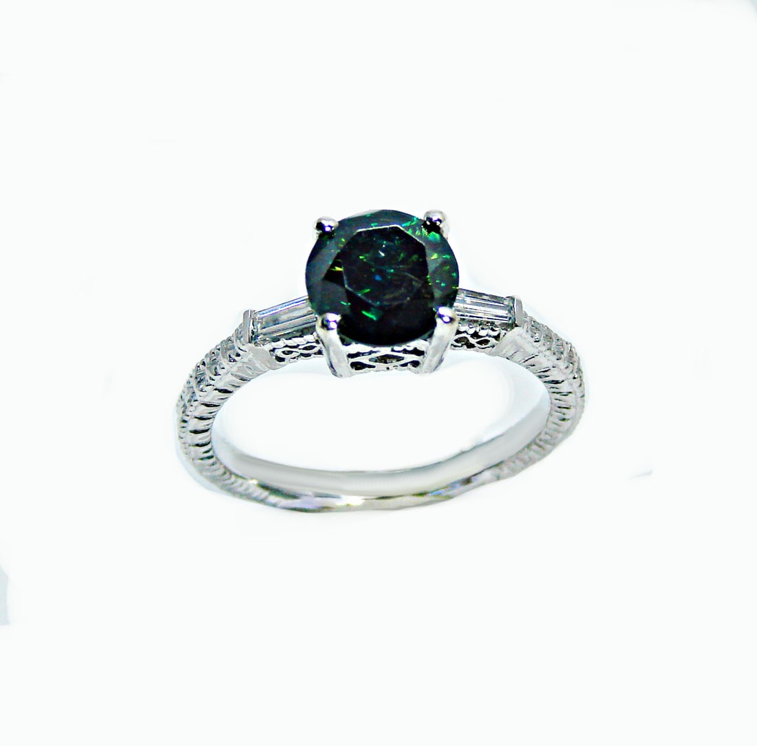 Enhanced Blue Diamond Ring 1.81 Carat 14k W/g: Gem Type: Enhanced Blue/White Diamond Qty: 1 Item: Ring Center: 1.60 Carat round 7.6x7.6mm(Clarity: SI3, Color: Fancy Dark Blue) Side total: .21 carat baguette (Clarity: SI1, Color: H) Metal: 14k whit