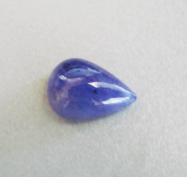 Tanzanite Cabochon Pear Shape 5.54Ct 13.5x9.3x5.6 mm: Gem:Natural Tanzanite Cabochon Pear Shape Weight:5.54 Carat Measurement: 13.5x9.3x5.6 mm Grade: A Clarity: SI3-Color: Light Violet/Blue Shape: Oval Cut: Cabochon Origin: Tanzania-Treatment: Heated <