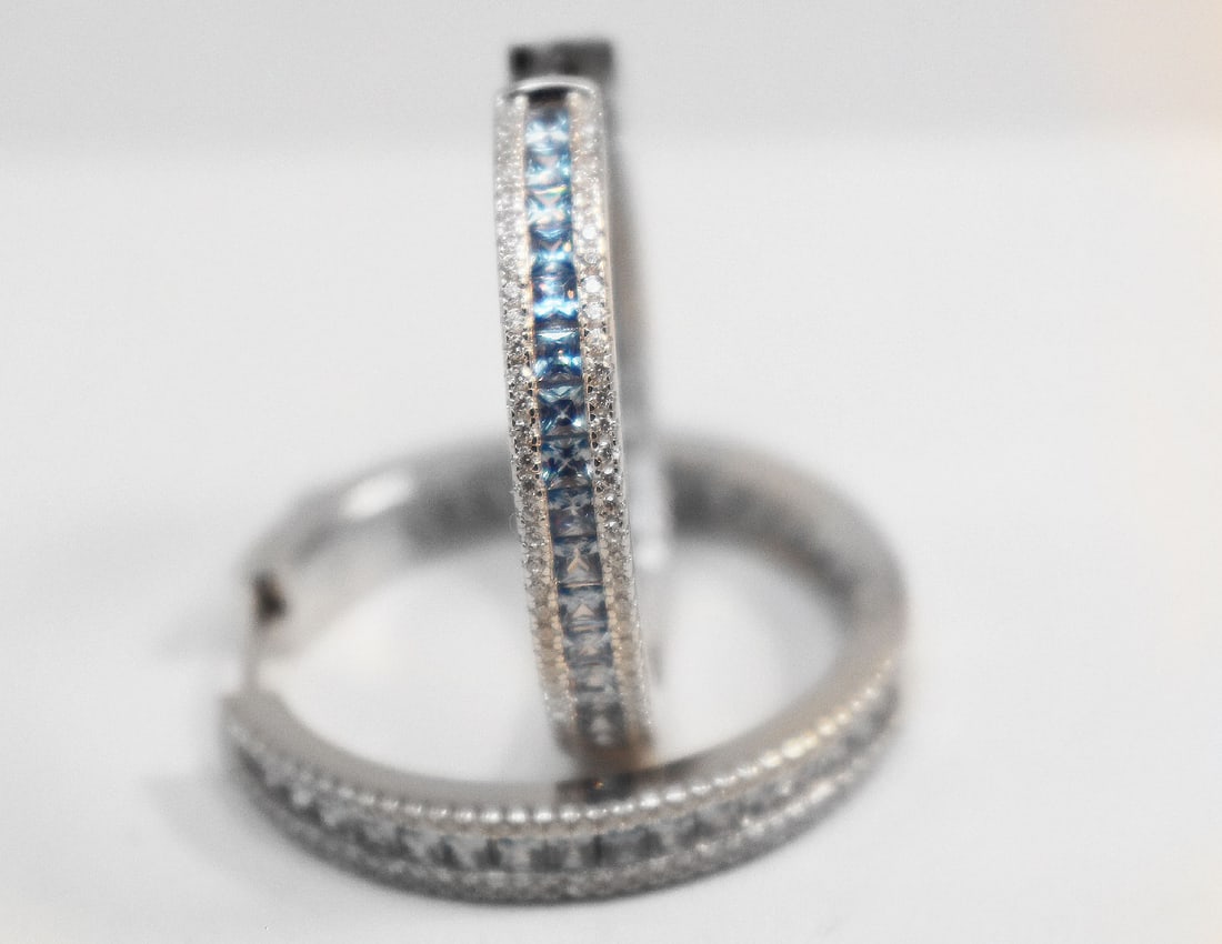 Creation Diamond/Blue Topaz Hoop Earrings 18kW/G Over: Gem Type: Creation Diamond/ Blue Topaz Item: Hoop Earrings, Size: 1.25 inches Diameter, Width: 4.5mm White Stone: 1.35 Carat round brilliant, Clarity: VS1, Color: G Blue Topaz: 1.60 Carat Princess Cut