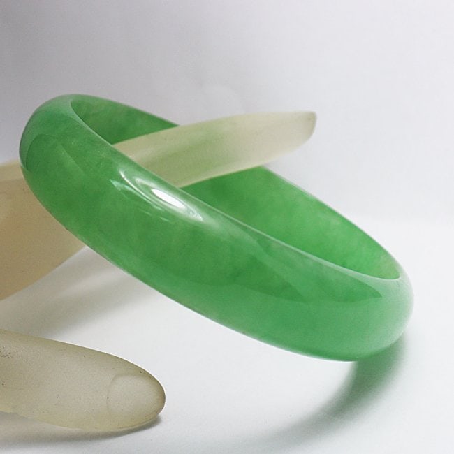 Translucent Solid Green Chinese Jade Bangle Size: 7: Gem Type: Natural Translucent Solid Chinese Jade Grade: B Item: Jade Bangle, Size 7 Outer Diameter: 61 mm Inter Diameter: 56mm Width: 14.5mm Thickness: 6.4 mm Weight 53.05 grams Treated: Untreated