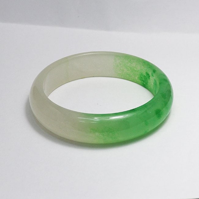 Translucent Solid Green/Creamy Chinese Jade Bangle Size: Gem Type: Natural Translucent Solid Chinese Jade Grade: B Item: Jade Bangle, Size 6.75 Outer Diameter: 68 mm Inter Diameter: 58 mm Width: 15mm Thickness: 8 mm Weight 55.19grams Treated: Untreated