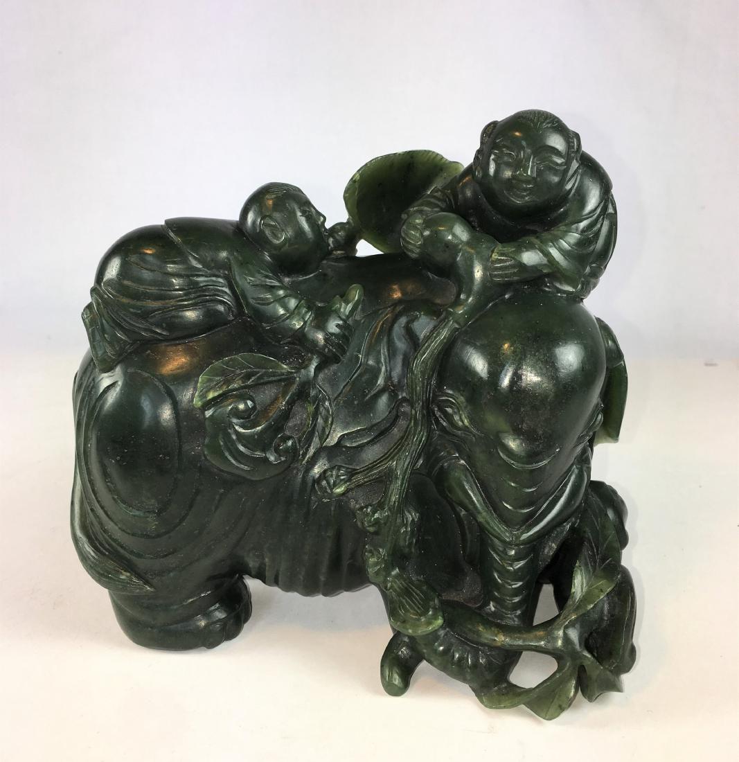 A Large Chinese Spinach Jade Carving - Boys on Elephant: Late Qing/Republic period, very heavy green jade stone in deep green color and semi-translucent, intricately carved two boys playing on the back of a large elephant; weight almost 4 lb. (60 oz.) or 18