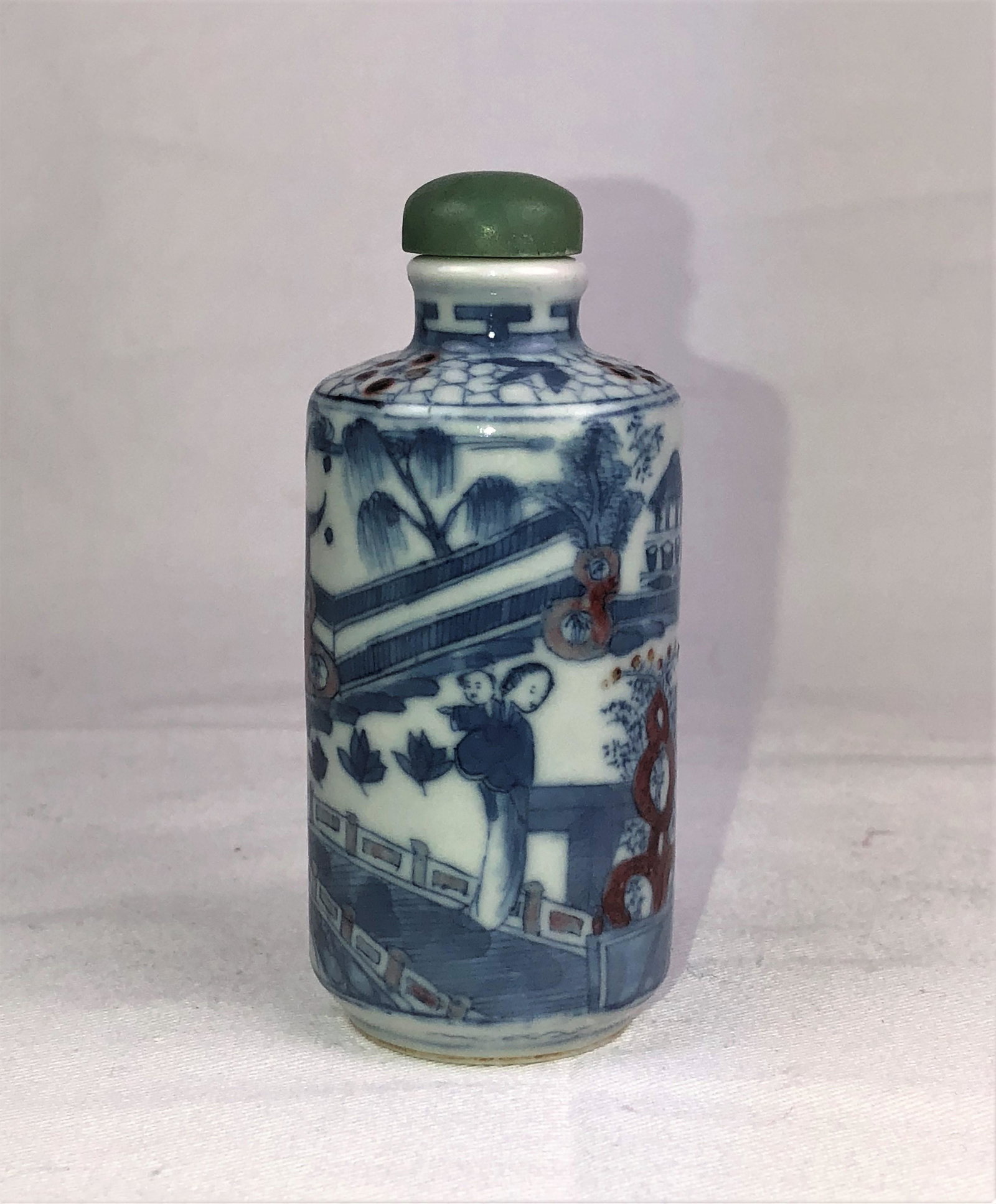 A Blue and White Porcelain Snuff Bottle, Qing Dynasty: Yongzheng mark, depicting figures in a mountain scene; 3 1/8 in. (7.8 cm) high