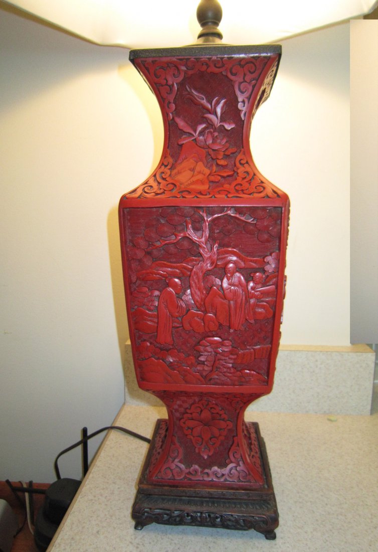 A Very Fine Chinese Cinnabar Square Vase Lamp: Qing Dynasty, early 19th Century, very fine square vase carved in all sides, depicting figures in landscape, mounted as a lamp with original pierced wood stand 清代雕漆方