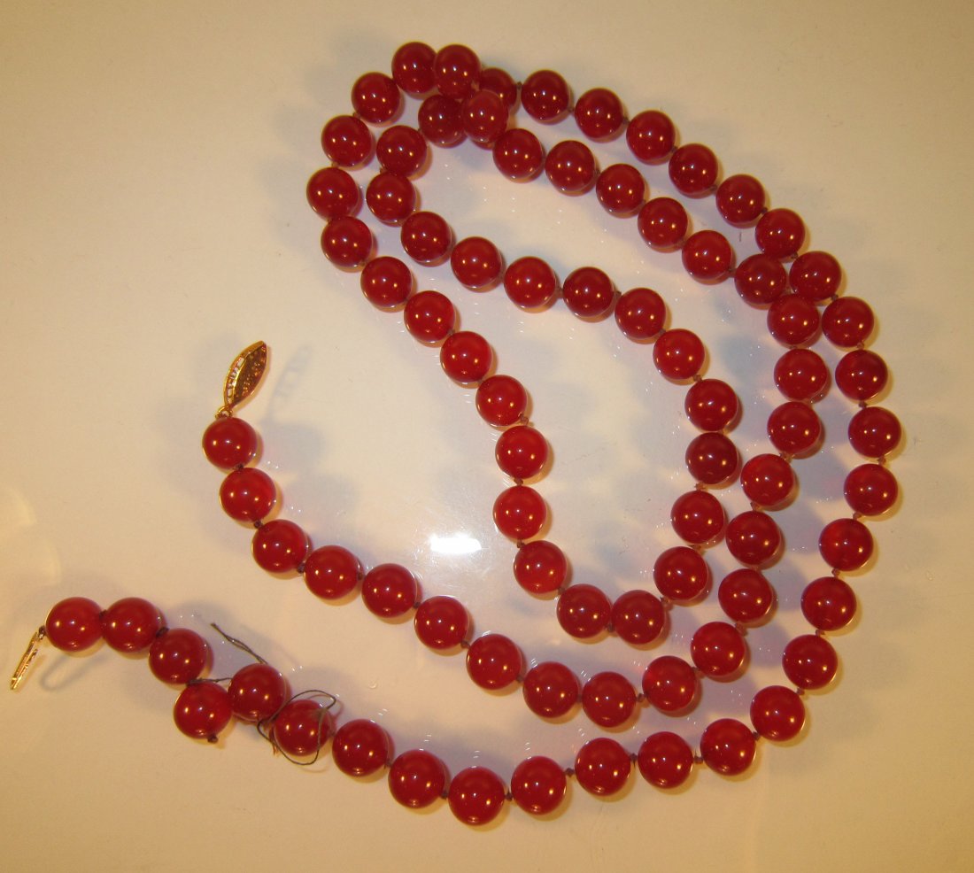 A Long Chinese Carnelian Beaded Necklace: A long strand of cherry red translucent carnelian beads, strung on an orange double knotted cording, 36 in. long, bead 9 cm diameter 红玛瑙珠子项链