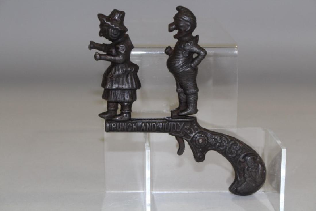 C. 1880s Ives Cast Iron Punch & Judy Animated Cap Gun: C. 1880s pistol / cap gun, Punch's nose slaps into Judy's back when trigger is pulled exploding cap on Judy's back. 5 1/4" L. Good working condition. Note first lot of several cast iron cap guns in th