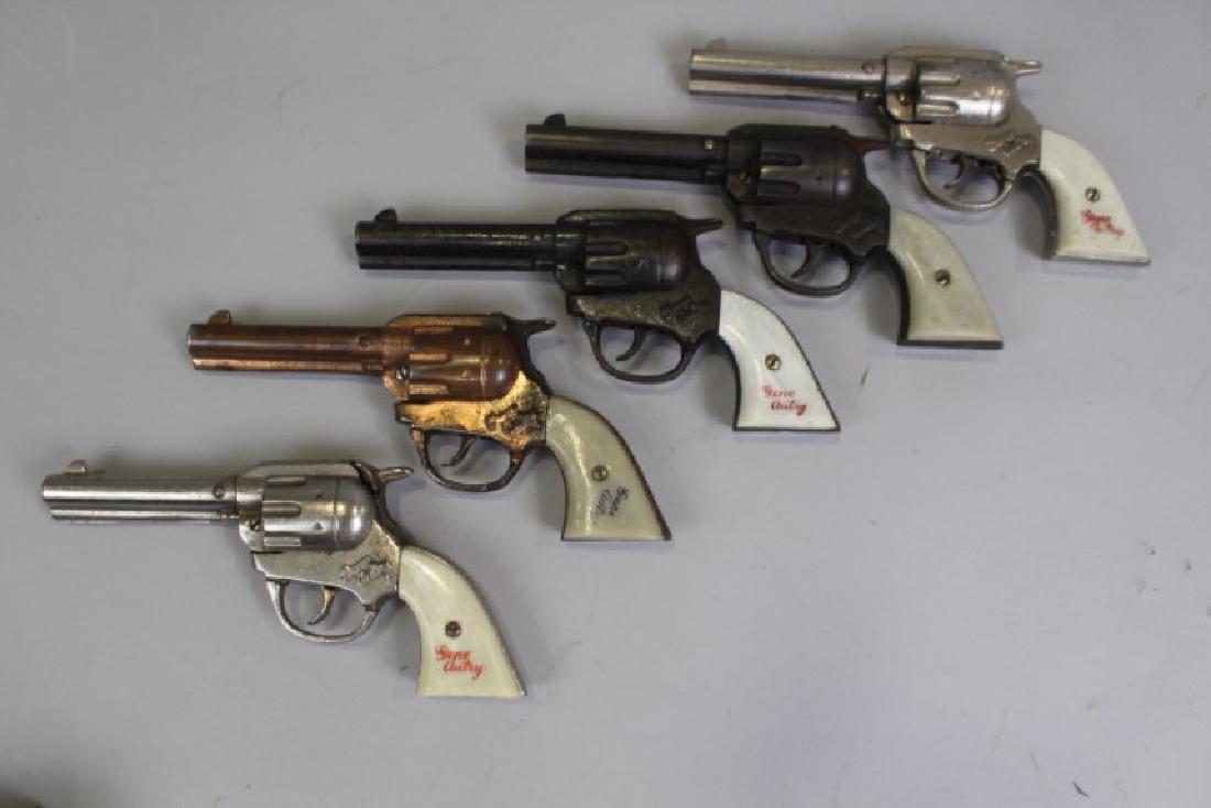 5 Kenton Gene Autry Toy Cap Guns: One with gold patina. All good working order.