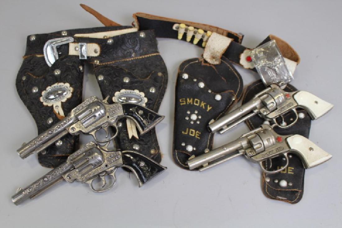 1940s Cap Guns in Double Holsters: 1940s - Stevens Peace Maker with faux lambs wool lining belt and back; Smoky Joe signed guns and metal attached names to the holsters. All good working order, Smoky Joe with tear to holster.