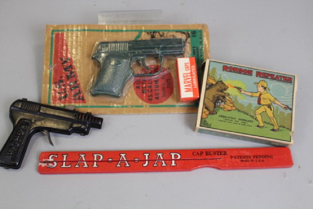 Group of Cap Gun Related Toys in Boxes: 1921 Art Metal Works Ronson Repeater cap gun in box, patent information imprinted on gun, box complete but ends detached; bubble packaged US Army cap gun with lubricated Marvel caps, unopened; Slap-A-