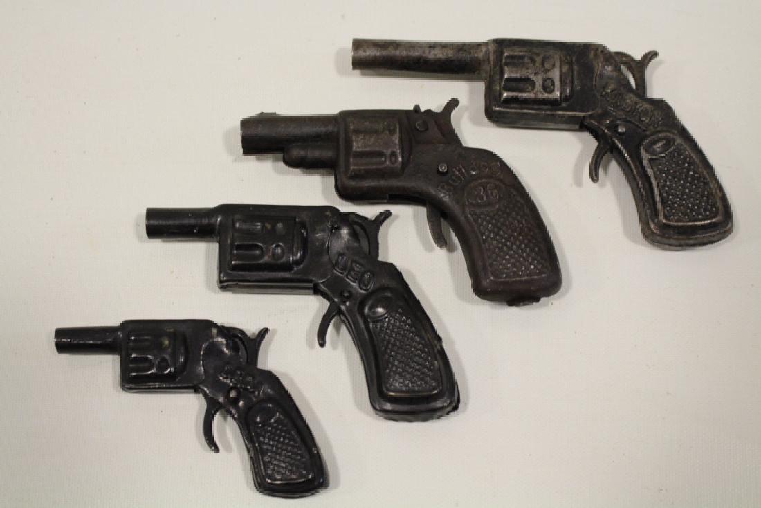 Lot of 4 Tin Toy Snub Nose Cap Guns - Graduated Sizes: Lot of 4 tin toy snub nose cap guns, fires single cap, squeeze trigger, 3 marked DRP, graduated sizes - smallest 3 1/4" marked Leda; Leo; Bulldog 36 Made in Germany; and largest Kastor. All triggers w