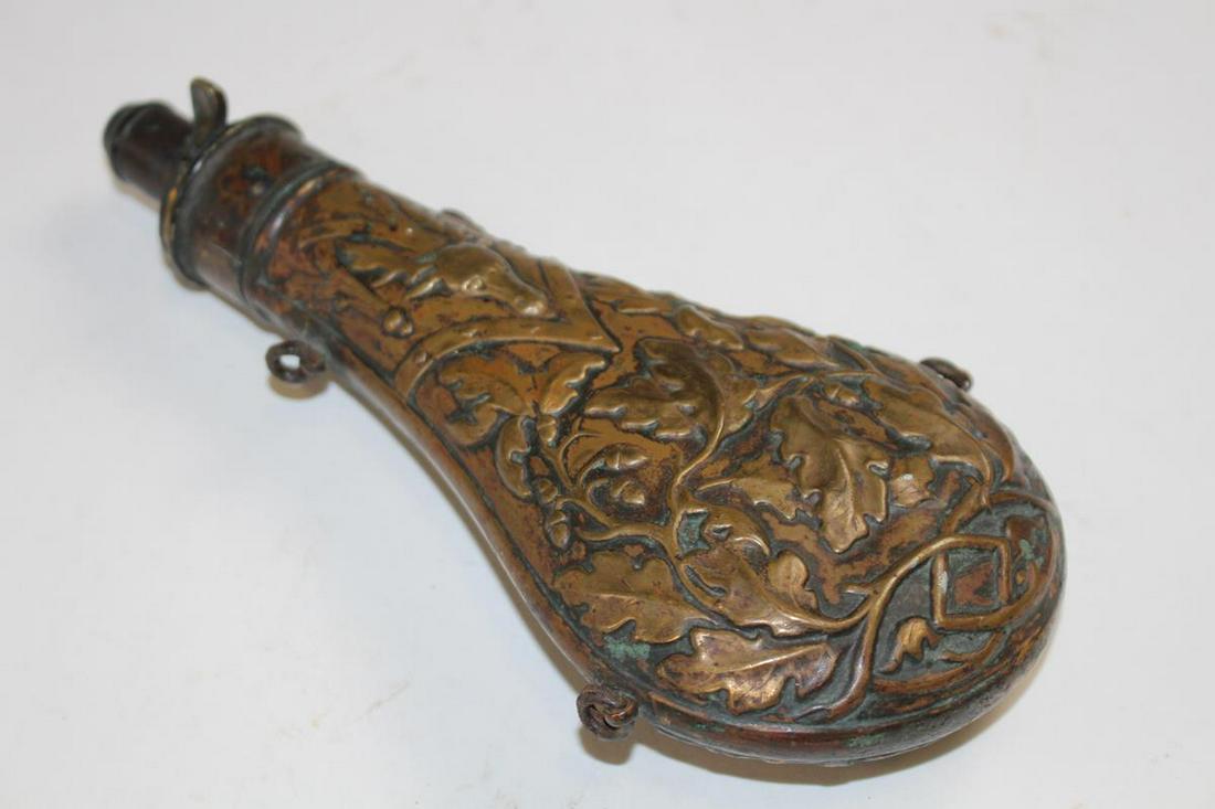 Early Brass Powder Horn Flask Stag & Foliage: Early ornate brass powder horn / flask, heavily embossed with deer / stag head and leaves, measure gauge, 9"H. very good condition.