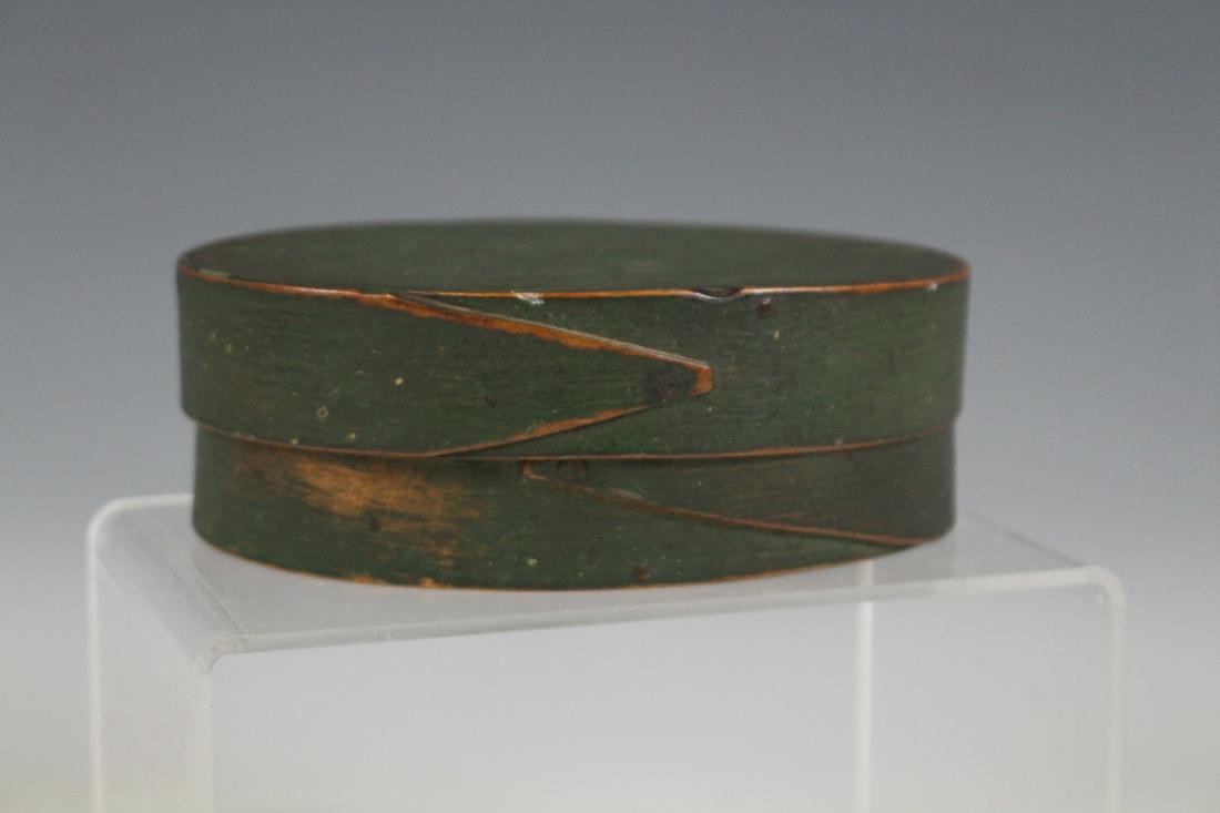 Shaker Green Painted Small Pantry Box: Shaker green-painted oval pantry box, single finger lap on lid and base, etched writing illegibly on underside, 5 1/2" W x 2" H. Minor expected paint wear.