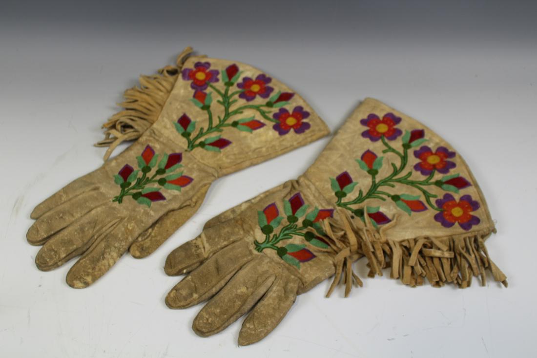 Early 20th C Northern Plains Indian Gauntlets: Circa early 1900s Northern Plains Native American Indian buckskin pair of gauntlets with fine-stitched embroidery and fringe, 13" L. Soiling, leather is soft, sturdy and pliable. No holes or tears.
