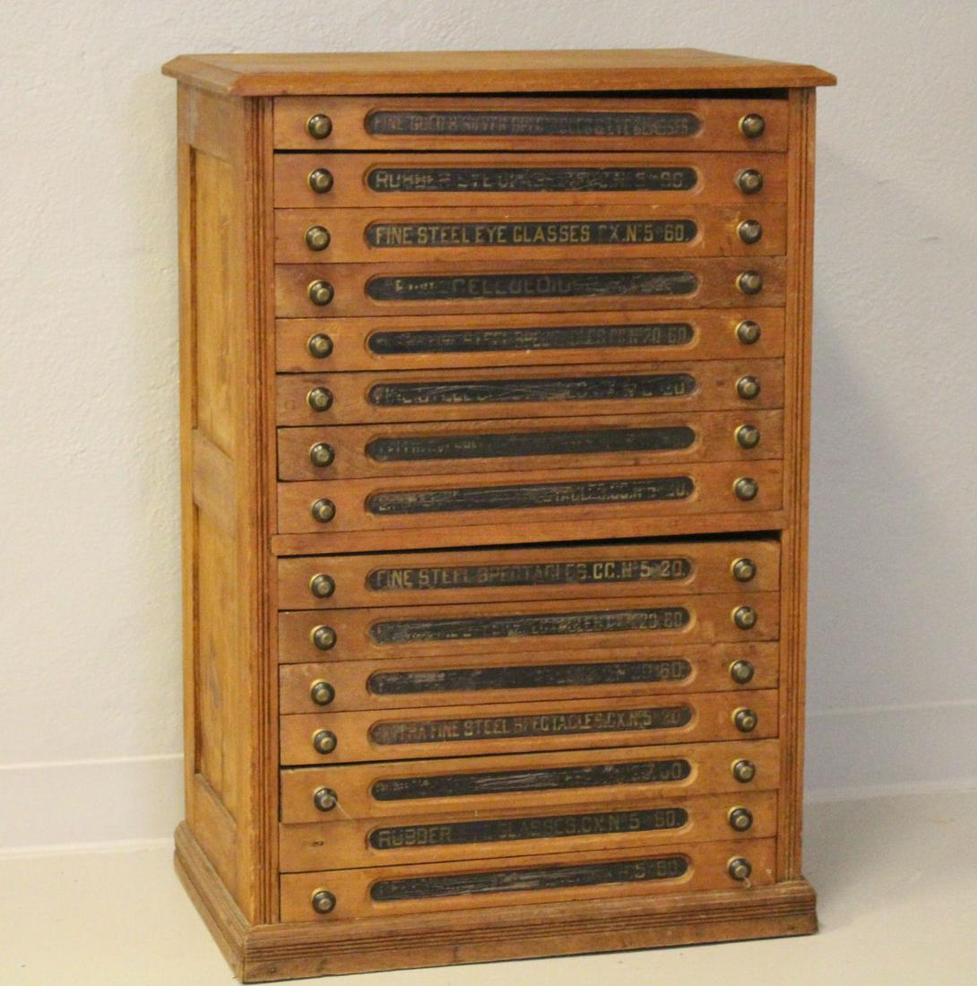 15 Drawer Eye Glass Optician's Salesman Case: 19th century, walnut, 15-drawer salesman's optician / eye glass cabinet, drawer fronts labeled as to type of eye glasses in drawer - i.e. "Fine Steel Eye Glasses CX No. 5 to 60", 23" H x 25" W x 17" D