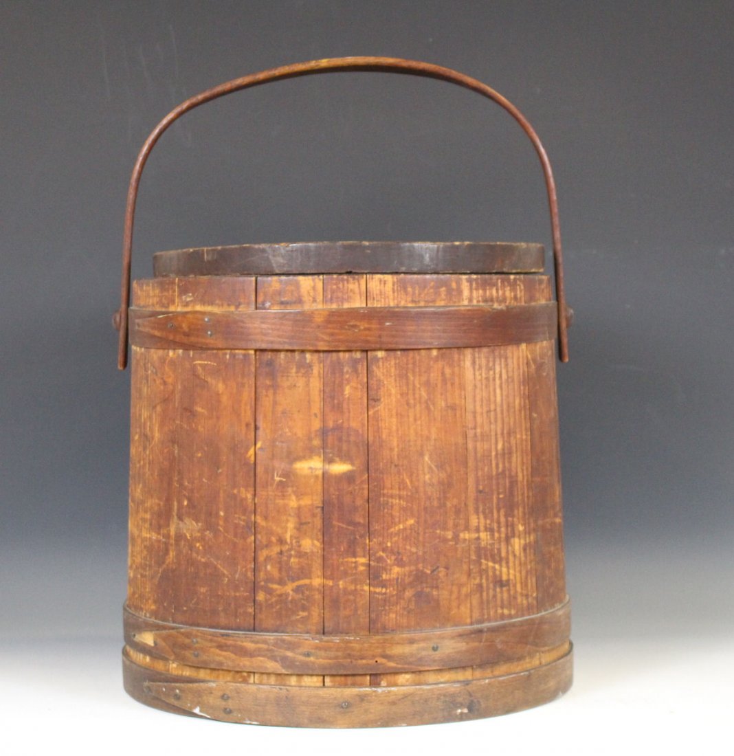 Large Store Counter Ash Wooden Firkin: Wide to narrow random alternating staves, single finger laps, hand-cut nails , swing handle with pegs, 15" W at top, 16" W at bottom, 15" H. Original lid replaced with very heavy, fitted, lid. Overall