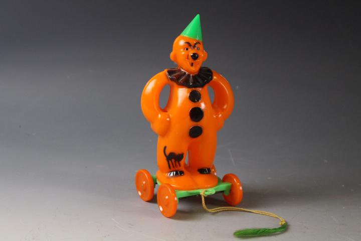 1950's Halloween Rosbro Plastic Pull Toy Clown: 1950's Halloween Rosbro Hard Plastic Clown on Wheels Pull Toy - original tasseled pull string, 6 1/4" H. MORE OF THIS LARGE HALLOWEEN COLLECTION IN THIS SALE - SELLING THROUGHOUT AUCTION INCLUDING SEV