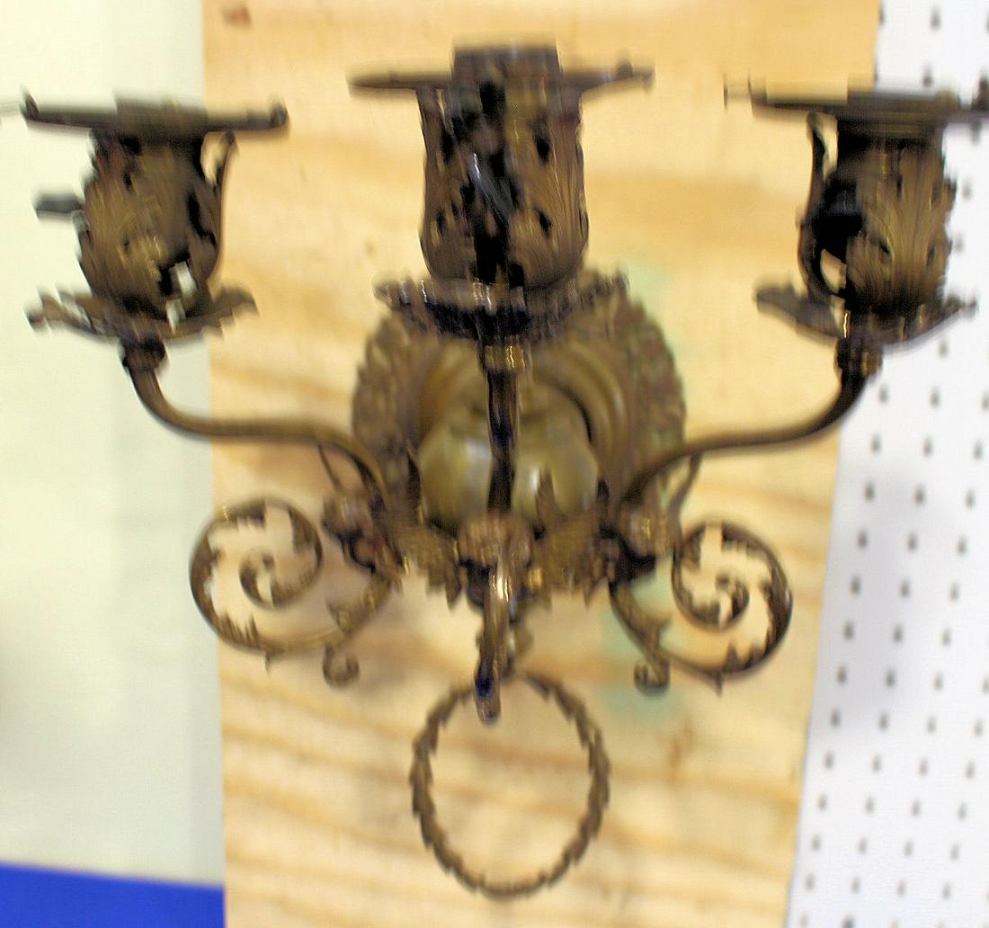 19th-Early 20th C Ornate Brass Sconce w/ Angels: 19th-Early 20th C Ornate Brass Sconce w/ Angels - three arms, original wiring, winged angel heads, ornate sockets and back, 15" H x 13" W x 12" protrusion, approximately 3 1/4" W shade collars, thumb 